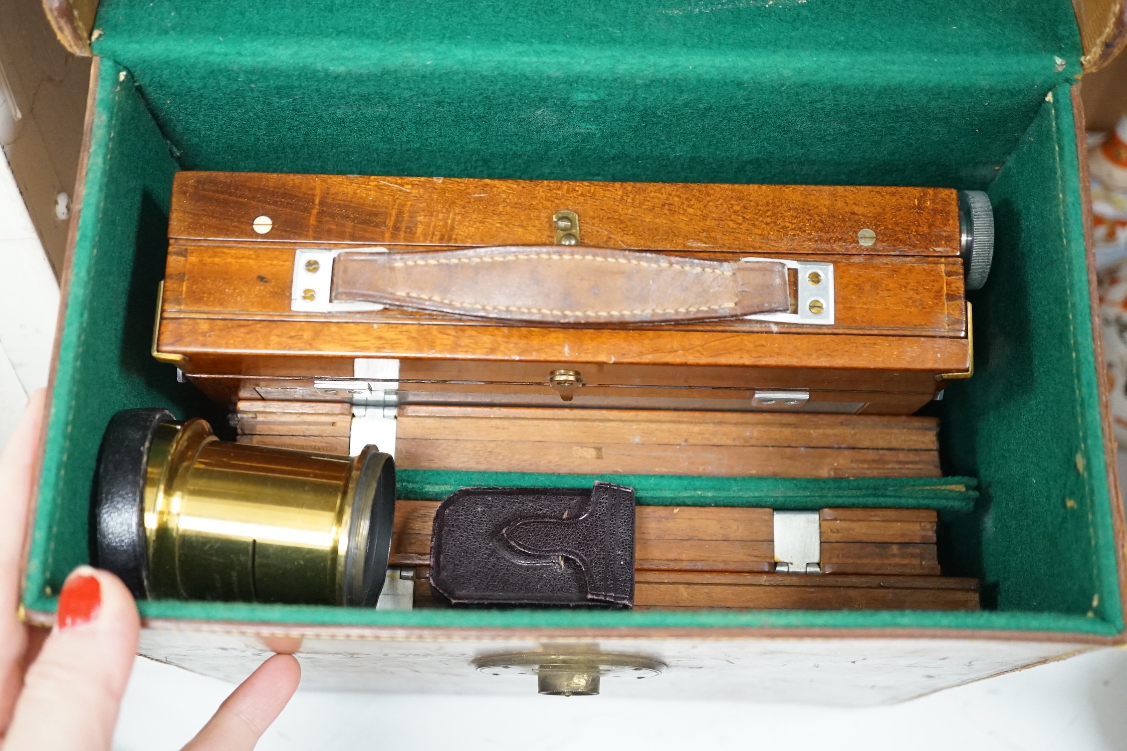 A leather cased Army & Navy auxiliary mahogany and brass folding camera, Newton & Co. Lens